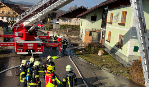 Hubrettungsbühne Mondsee und Mannschaft im Vordergrund bei Vollbrand Löscharbeiten